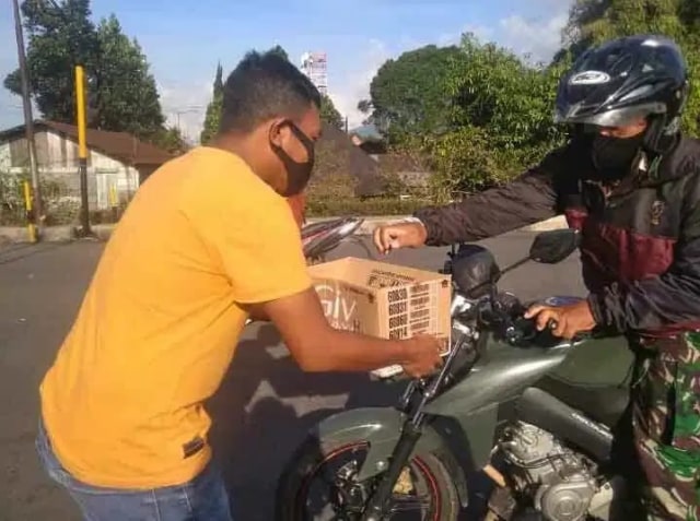 Foto: Seorang pemuda menyodorkan kotak kepada para pengendara motor dan mobil di kota Ruteng, dalam aksi kemanusian untuk pengobatan Putri dan Neira. Foto: istimewa.