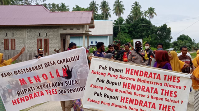 Masyarakat Desa Capalulu mentangkan spanduk penolakan Bupati Kepulauan Sula Hendrata Thes. Foto: Istimewa