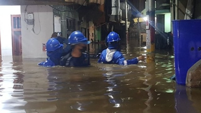 Petugas dari Kelurahan Kampung Melayu meninjau dampak banjir yang melanda Kebon Pala, Jakarta Timur, Senin (5/10),  Foto: Kelurahan Kampung Melayu/via ANTARA