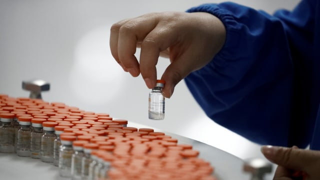 Seorang pekerja bekerja di fasilitas pengemasan pembuat vaksin Sinovac Biotech. Foto: Thomas Peter/REUTERS