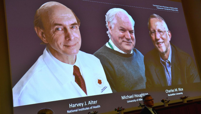 Harvey J. Alter, Michael Houghton dan Charles M. Rice, terlihat di layar sebagai tiga pemenang saat mereka diumumkan sebagai pemenang Hadiah Nobel 2020. Foto: REUTERS/Claudio Bresciani 
