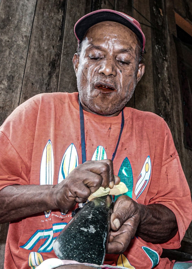 Perajin menggosok tomako batu sambil mendoakan batu tersebut untuk dijadikan mahar atau maskawin di Kampung Yoka, Kota Jayapura, Papua. Foto: Indrayadi TH/ANTARA FOTO