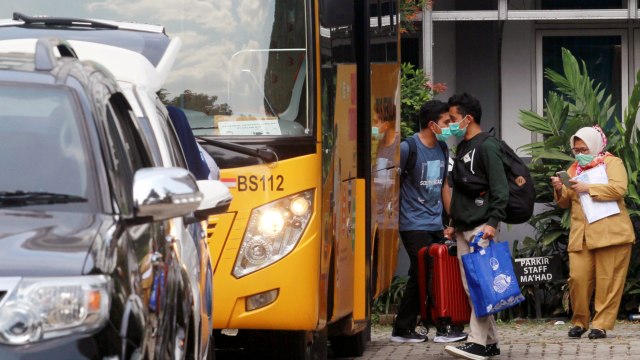 Seorang mahasiswa Perguruan Tinggi Ilmu Al Quran (PTIQ) yang dinyatakan positif COVID-19 menaiki bus saat dievakuasi dari asrama PTIQ Lebak Bulus, Jakarta, Senin (5/10).  Foto: Muhammad Iqbal/ANTARA FOTO