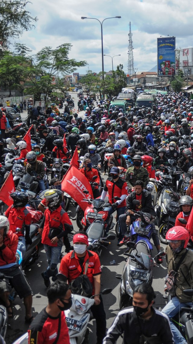 Ratusan buruh memblokir jalan nasional Bandung-Garut--Tasikmalaya saat melakukan aksi di Rancaekek, Kabupaten Bandung, Jawa Barat, Selasa (6/10). Foto: Raisan Al Farisi/ANTARA FOTO