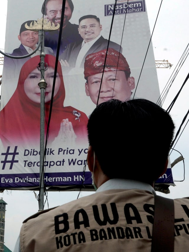 Petugas gabungan Bawaslu dan Polisi Pamong Praja Kota Bandar Lampung mencopot poster alat peraga kampanye (APK) di Bandar Lampung, Lampung, Minggu (27/9). Foto: Ardiansyah/ANTARA FOTO
