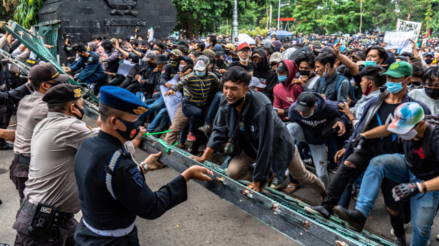 Massa gabungan dari buruh dan mahasiswa merobohkan pagar kompleks gedung DPRD Jateng saat berunjuk rasa menolak Omnibus Law di depan gedung DPRD Jateng, Kota Semarang, Jawa Tengah, Rabu (7/10) Foto: Aji Styawan/ANTARA FOTO