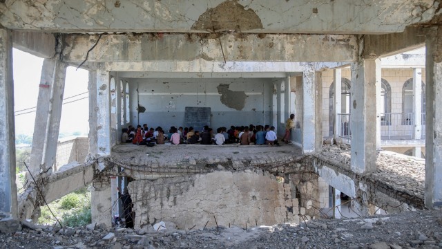 Sejumlah siswa Yaman menghadiri kelas pada hari pertama tahun ajaran baru, di ruang kelas sementara di kompleks sekolah mereka yang rusak, di Taez, Yaman. Foto: AHMAD AL-BASHA/AFP