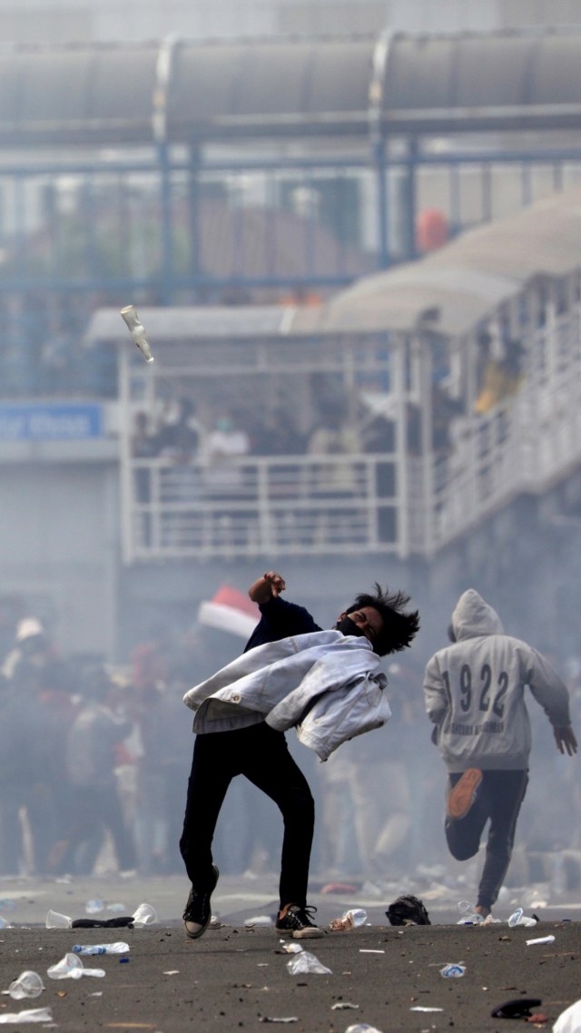 Massa aksi melempar botol kearah polisi saat aksi unjuk rasa tolak Omnibus Law di dekat Istana Kepresidenan, Jakarta, Kamis (8/10). Foto: Willy Kurniawan/REUTERS