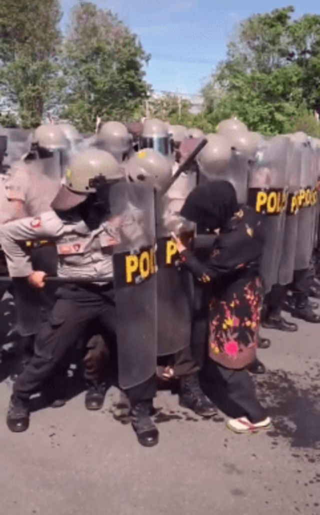 Emak-emak santai ambil sandal tembus barikade polisi yang berjaga di tengah demo. (Foto: TikTok @natc.jeje)