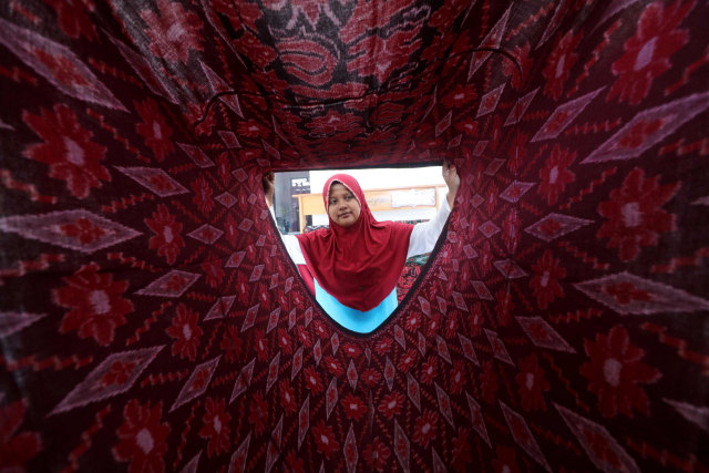 Perajin membuat sarung tenun dengan alat tenun bukan mesin di Kampung Tenun, Kelurahan Bandar Kidul, Kota Kediri, Jawa Timur. Foto: Prasetia Fauzani/Antara Foto