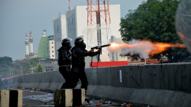 Polisi menembakkan gas air mata ke arah pengunjuk rasa saat terjadi bentrok di Makassar, Sulawesi Selatan, Kamis (8/10). Foto: Abriawan Abhe/ANTARA FOTO