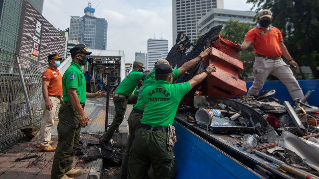 Sejumlah petugas membersihkan puing Halte Bus Trans-Jakarta Tosari yang hangus saat kericuhan unjuk rasa menolak Omnibus Law di Jalan MH. Thamrin, Jakarta, Jumat (9/10). Foto: Aditya Pradana Putra/ANTARA FOTO