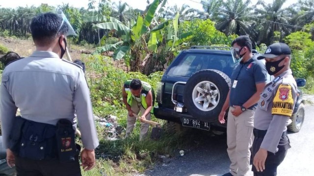 Pelanggar protokol kesehatan di Pasangkayu, Sulawesi Barat, diberikan sanksi sosial mencangkul rumput. Foto: Dok. Polres Pasangkayu