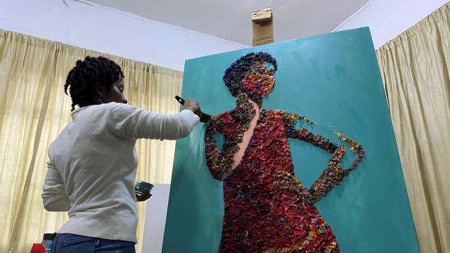 Marcellina Akpojotor menciptakan karya seni seorang wanita dengan masker wajah menggunakan limbah kain Ankara di Lagos, Nigeria. Foto: SEUN SANNI/REUTERS