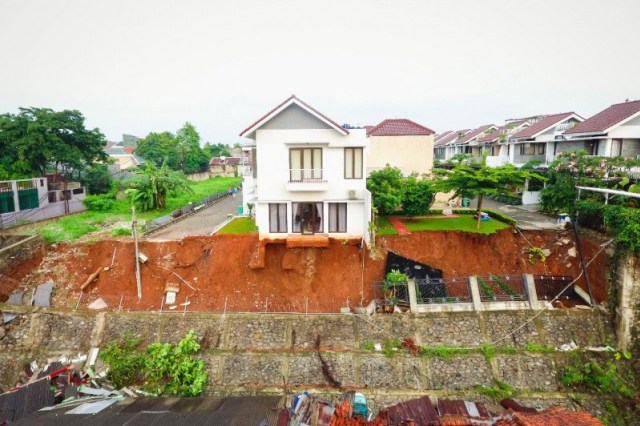 Kondisi tembok pembatas kali di pemukiman yang roboh menutup aliran Kali Anak Setu, Kelurahan Ciganjur, Jagakarsa, Jakarta Selatan, Minggu (11/10). Foto: HO-Damkar Jakarta Selatan/Antara