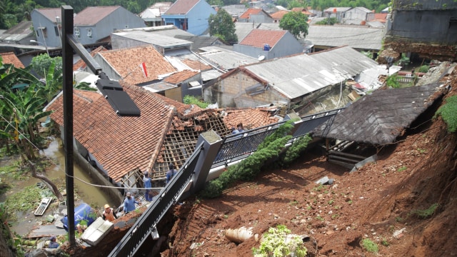 Petugas bersama relawan membenahi rumah warga yang rusak akibat tanah longsor di kawasan Ciganjur, Jakarta, Minggu (11/10).  Foto: Reno Esnir/ANTARA FOTO