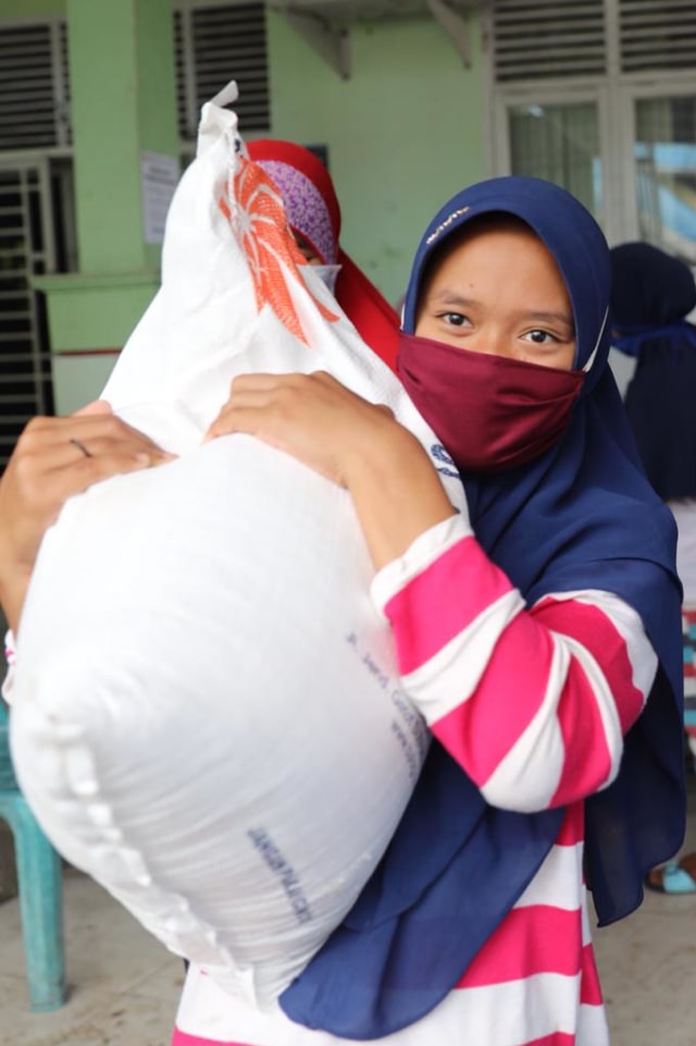 Warga di Kecamatan Kuta Raja, Kota Banda Aceh, menerima bantuan sosial beras dari Kemensos, Senin (12/10). Foto: Suparta/acehkini