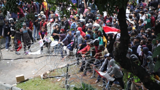 Massa aksi merusak barikade kawat berduri saat unjuk rasa menolak Omnibus Law, di Kawasan Monas, Jakarta, Selasa (13/10).  Foto: Aditia Noviansyah/kumparan