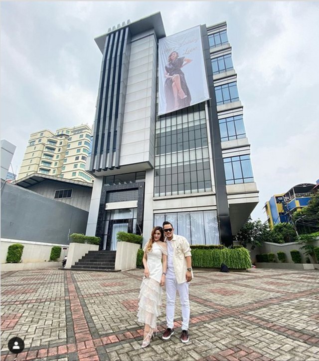 Gilang dan istrinya berpose di depan gedung tower yang jadi hadiah ultah sang istri (Foto: Instagram/juragan_99)