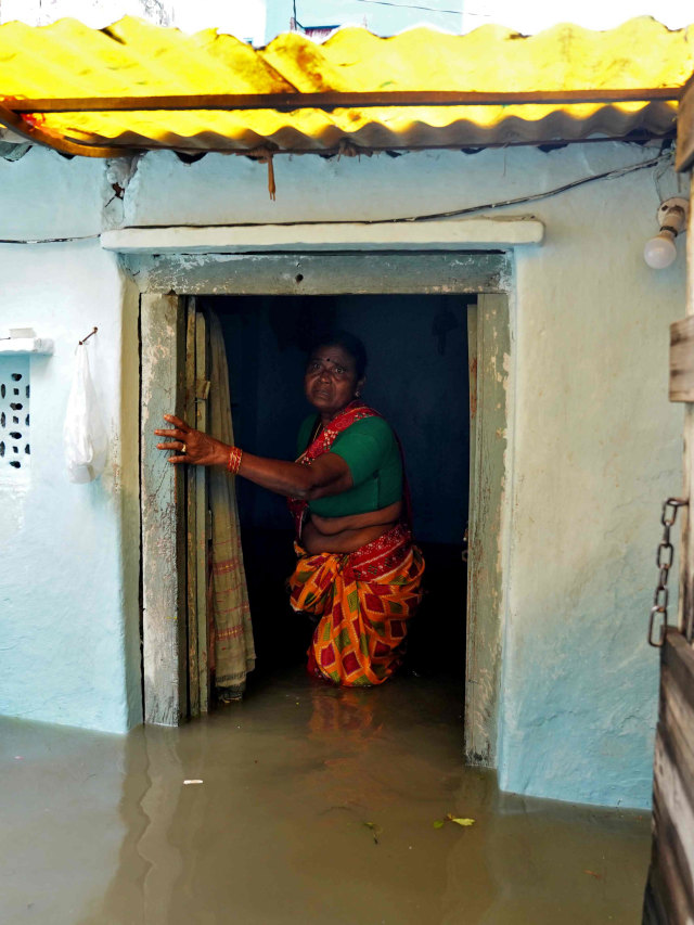 Seorang wanita di rumahnya yang tergenang banjir di Hyderabad, India. Foto: Vinod Babu/Reuters