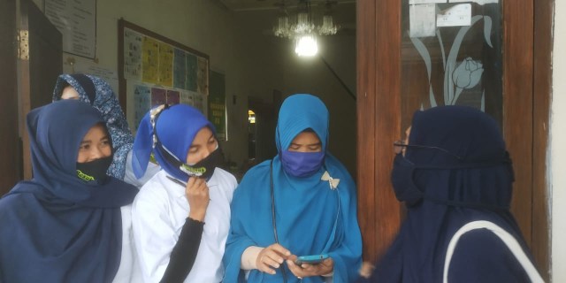 Ibu-Ibu di Kota Malang tetap memakai masker kendati beraktivitas. Foto: Ulul Azmy