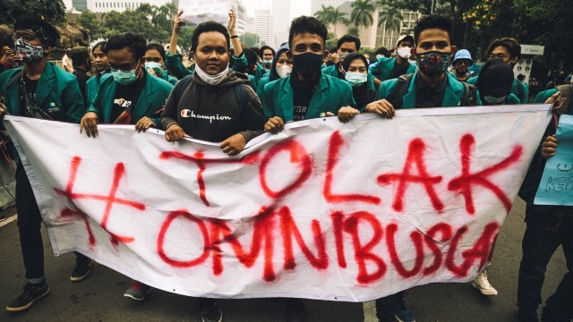 Massa dari BEM SI membentangkan spanduk saat berunjuk rasa menolak Omnibus Law di kawasan Patung Kuda, Merdeka Barat, Jakarta, Jumat (16/10). Foto: Aditia Noviansyah/kumparan