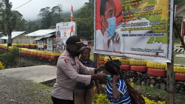 Polisi di Bokondini, Kabupaten Tolikara bagikan masker kepada mama pedagang asli Papua. (Dok Polda Papua)