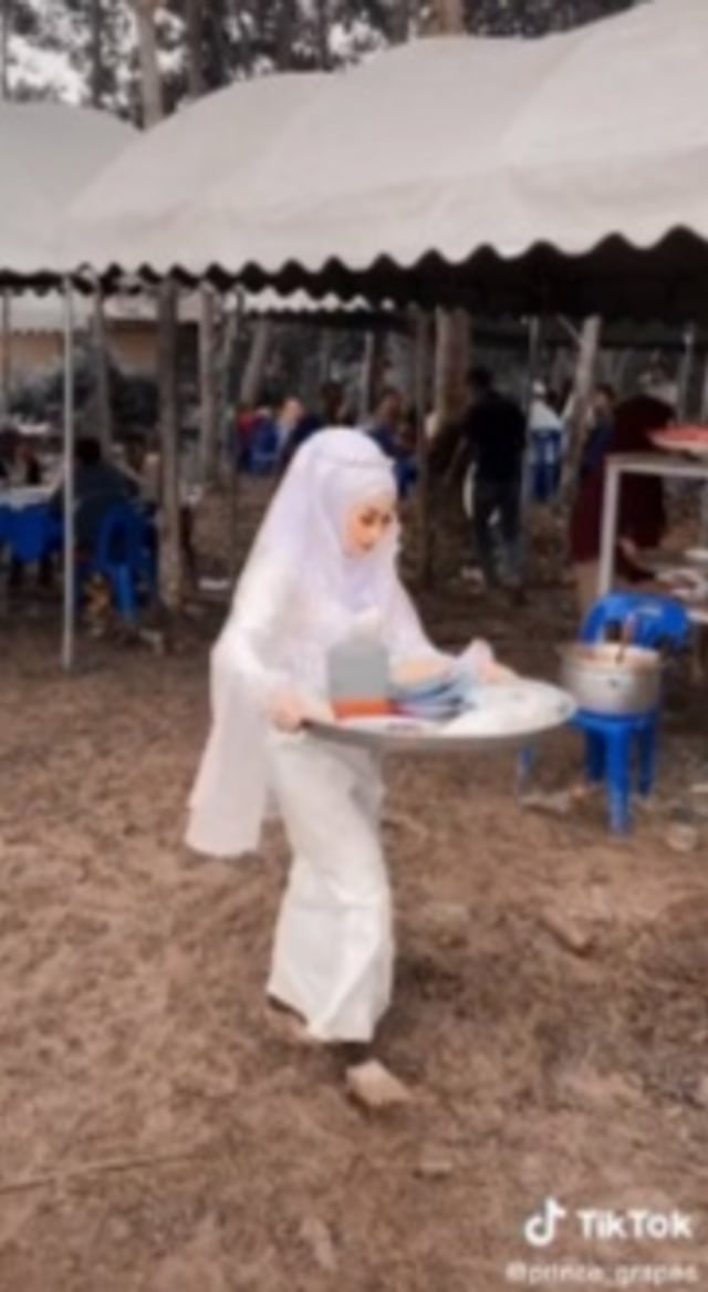 Viral sepasang penganti di Thailand Selatan malah angkat piring kotor hingga melayani tamu undangan di pesta pernikahan sendiri. (Foto: TikTok/@PrinceGrapes)