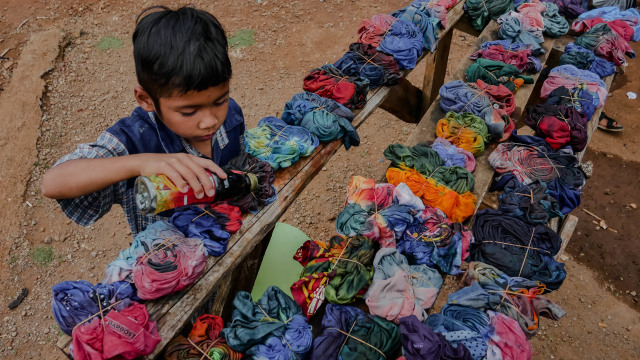 Anak-anak mewarnai baju bekasnya untuk dibuat baju tie dye. Foto: Jamal Ramadhan/kumparan