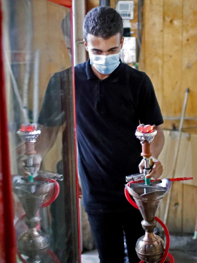 Seorang pekerja menyiapkan shisha, di tengah merebaknya wabah virus corona di Baghdad, Irak. Foto: Thaier Al-Sudani/Reuters