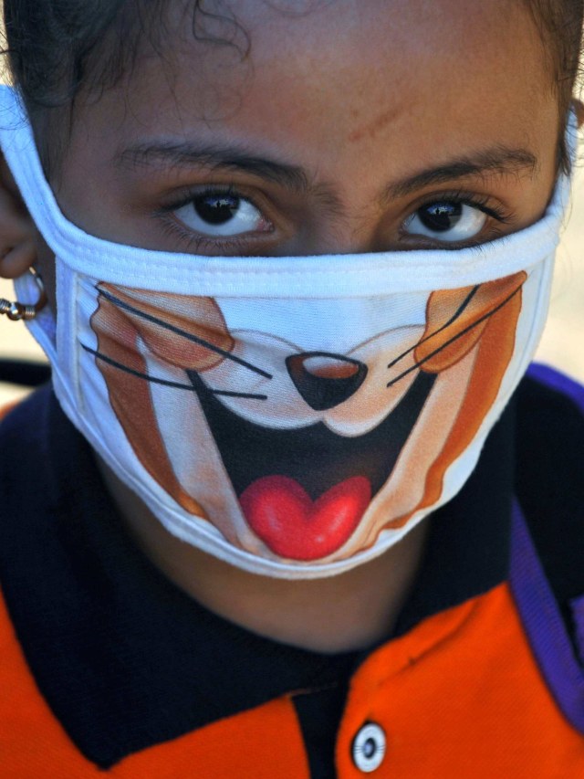 Salah satu siswa menggunakan masker di hari pertama kembali ke sekolah di El Safa, pinggiran Giza, Awsim, Mesir. Foto: Shokry Hussien/Reuters