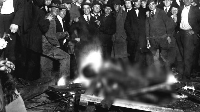 Orang-orang kulit putih mengerumuni korban kulit hitam yang dibakar dalam kerusuhan di AS pada 1919 | Wikimedia Commons