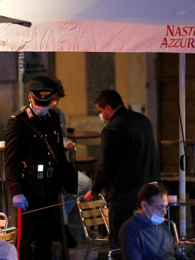 Pemeriksaan dilakukan oleh petugas Carabinieri Italia untuk menerapkan aturan baru di restoran. Foto: Yara Nardi/Reuters