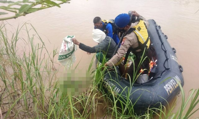 Petugas Polresta Palangka Raya saat melakukan evakuasi terhadap mayat bayi perempuan yang ditemukan mengambang di Sungai. 