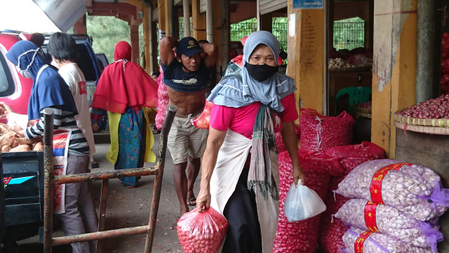 Bu Tumijem, salah seorang buruh gendong di Pasar Beringharjo sedang membawa bawang. Foto: Widi Erha Pradana.