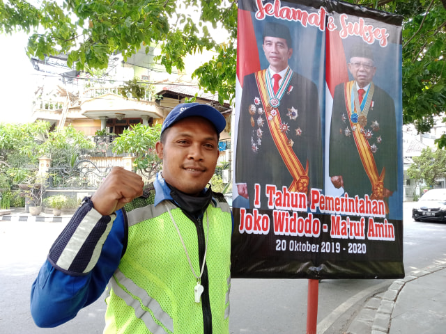 Seorang warga Solo yang berprofesi sebagai Supeltas terlihat membawa spanduk yang bertuliskan ucapan selamat dan sukses atas 1 tahun pemerintahan periode kedua Joko Widodo-Ma'aruf Amin