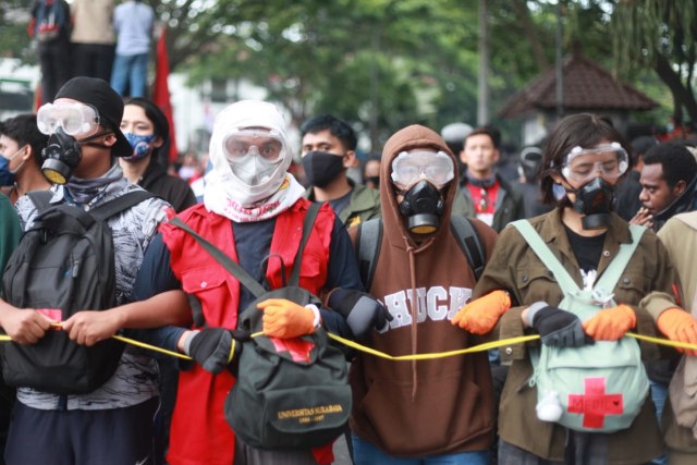 Relawan medis mengenakan masker dan kacamata saat aksi penolakan Omnibus Law di Malang. Foto: Ben
