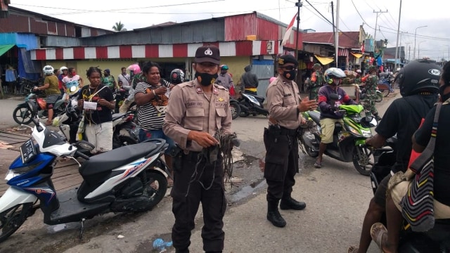 Polisi di Timika bagikan masker kepada warga yangtak gunakan masker di luar rumah. (Dok Polda Papua)