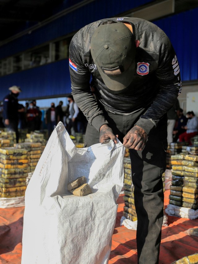 Petugas membuka paket kokain yang disembunyikan dalam pengiriman enam kontainer arang yang akan dikirim ke Israel yang disita unit anti-narkotika Paraguay. Foto: Jorge Adorno/Reuters