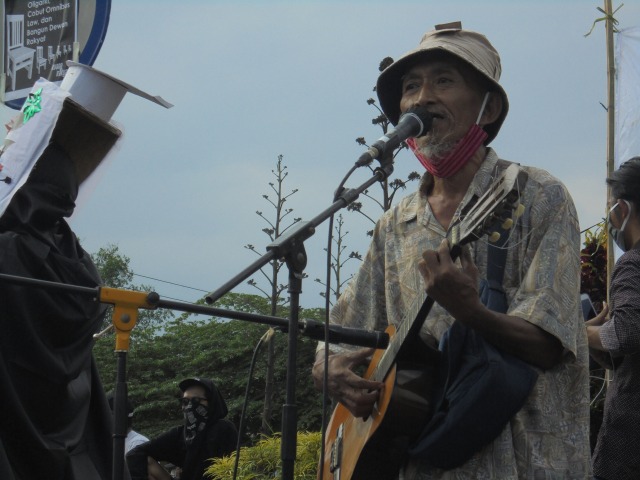 Mbah Bambang menyanyikan lagu-lagu yang membakar semangat massa pada aksi di Bundaran UGM, Selasa (19/10). Foto: Widi Erha Pradana. 