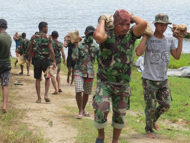 Personel TNI Kodim Kaimana saat mengangkat material rumah