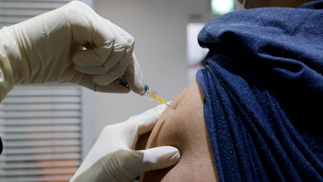 Seorang warga mendapat vaksin influenza di cabang Asosiasi Promosi Kesehatan Korea di Seoul, Korea Selatan, Jumat (23/10). Foto: Kim Hong-Ji/REUTERS