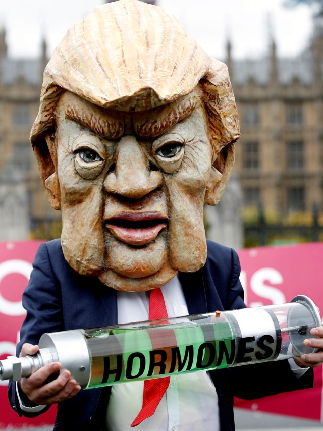 Seseorang yang berpakaian seperti Presiden AS Donald Trump memegang suntikan hormon palsu selama demonstrasi menjelang pemilihan presiden AS, di London, Inggris, Sabtu (24/10). Foto: Peter Nicholls/REUTERS