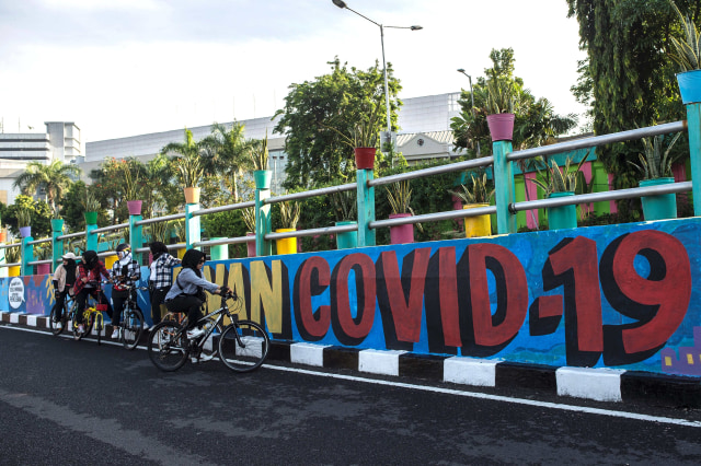 Mural ajakan untuk melawan COVID-19 di Surabaya. Foto: Juni Kriswanto/AFP