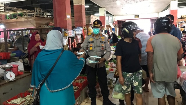 Kapolres Merauke, AKBP Untung Sangaji bagikan masker pada pengunjung Pasar Wamanggu. (Dok Polda Papua)