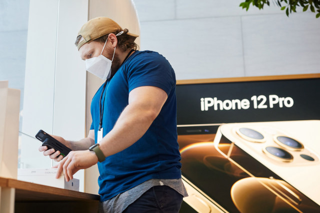 Karyawan Apple Store di Highland Village, Texas, AS, tengah menyiapkan iPhone 12 untuk pembeli. Foto: Apple