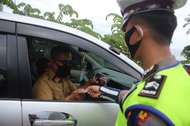 Salah seorang anggota kepolisian Polres Kolaka Utara saat melakukan pemeriksaan kepada pengguna jalan pada Operasi Zebra. Foto: Lukman Budianto/kendarinesia. 