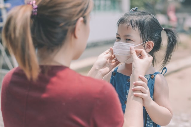 Ilustrasi memakaikan masker kepada anak. Foto: Shutterstock