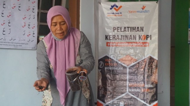 Ibu Srianah, salah satu Fasilitator menjelaskan teknis pembuatan kerajinan kopi kepada anggota lainnya di Basecamp BISA Wonosalam, Jombang. 