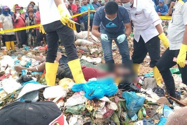 Petugas kepolisian mengambil gambar mayat laki-laki di tumpukan sampah TPA Punggur, Batam. (Foto: ist)
